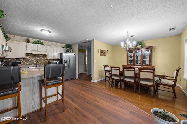 119 Cobblestone Trl, Jacksonville, NC 28546 - kitchen with stainless steel fridge with ice dispenser, a chandelier, range hood, dark wood-type flooring, and a sink