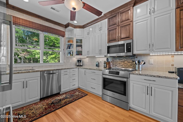 1404 Tosto Cir Apt 5, Oriental, NC 28571 - kitchen featuring stainless steel appliances, ceiling fan, light wood finished floors, decorative backsplash, and white cabinetry