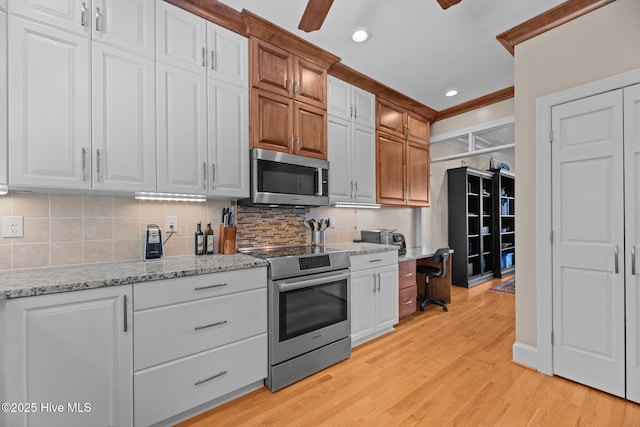 1404 Tosto Cir Apt 5, Oriental, NC 28571 - kitchen featuring stainless steel appliances, tasteful backsplash, light wood-style flooring, light stone counters, and white cabinets