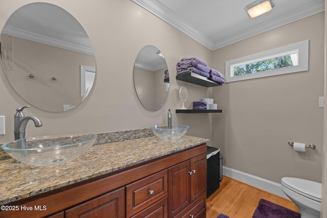 1404 Tosto Cir Apt 5, Oriental, NC 28571 - bathroom featuring wood finished floors, double vanity, toilet, ornamental molding, and baseboards