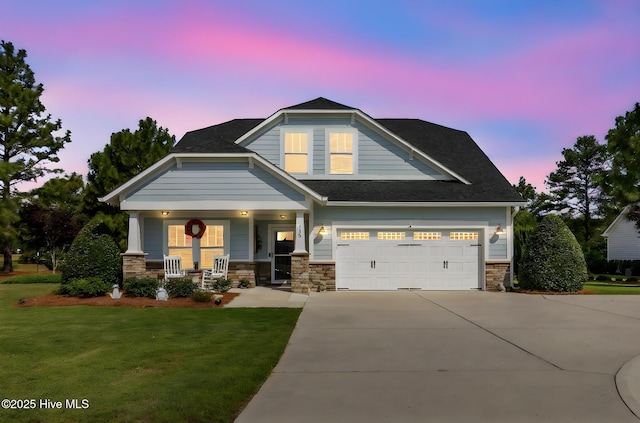 115 Norman Cir, Aberdeen, NC 28315 - view of front facade with covered porch, concrete driveway, a lawn, stone siding, and roof with shingles