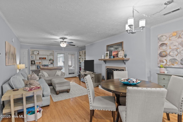 1825 Savannah Ct Unit D3, Wilmington, NC 28403 - dining space featuring crown molding, a fireplace, light wood finished floors, a textured ceiling, and ceiling fan