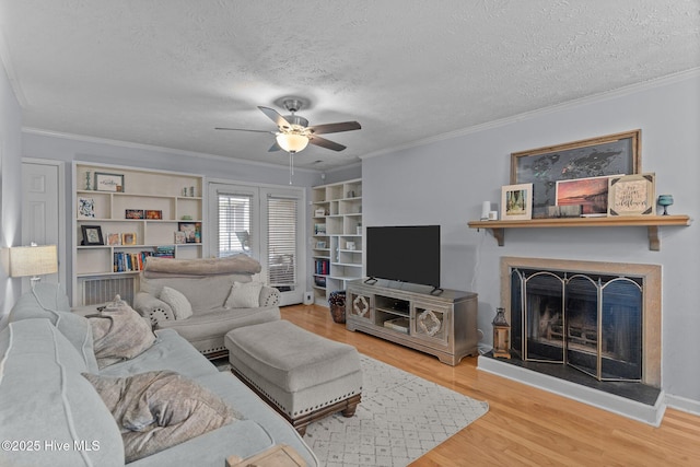 1825 Savannah Ct Unit D3, Wilmington, NC 28403 - living room featuring a fireplace with raised hearth, a ceiling fan, wood finished floors, crown molding, and a textured ceiling