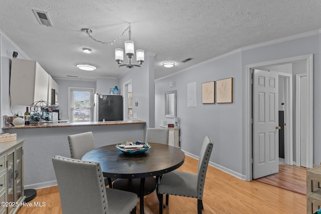 1825 Savannah Ct Unit D3, Wilmington, NC 28403 - dining space with light wood-type flooring, ornamental molding, a chandelier, a textured ceiling, and baseboards