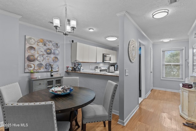 1825 Savannah Ct Unit D3, Wilmington, NC 28403 - dining space featuring crown molding, light wood-type flooring, a textured ceiling, baseboards, and a chandelier