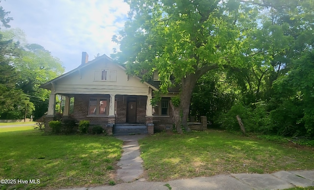 301 S Commerce St, Aulander, NC 27805 - view of front of home featuring a front lawn, a porch, and brick siding