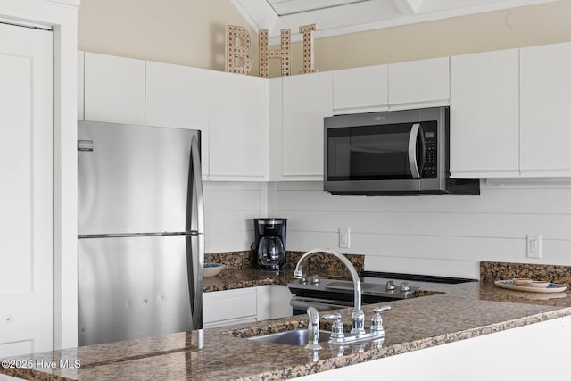 305 S Bald Head Wynd Wynd Unit 16, Bald Head Island, NC 28461 - kitchen featuring stainless steel appliances, white cabinets, dark stone countertops, a sink, and ornamental molding
