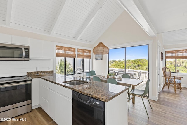 305 S Bald Head Wynd Wynd Unit 16, Bald Head Island, NC 28461 - kitchen featuring stainless steel appliances, a sink, a peninsula, white cabinetry, and light wood finished floors
