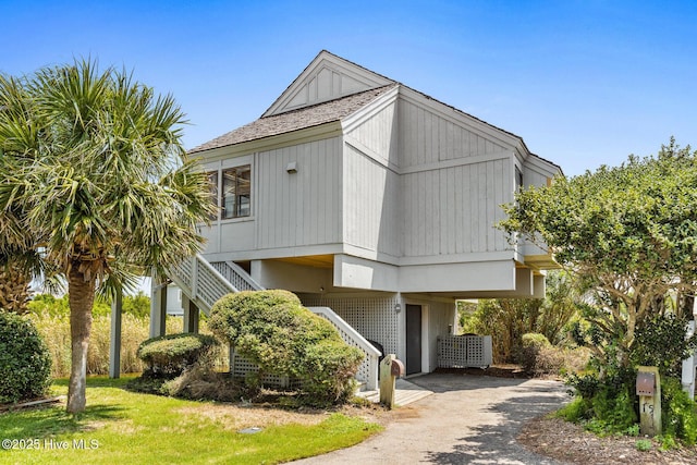 305 S Bald Head Wynd Wynd Unit 16, Bald Head Island, NC 28461 - view of front of house featuring stairway, a carport, and asphalt driveway