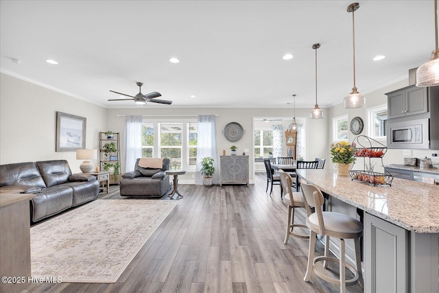 3213 Laughing Gull Ter, Wilmington, NC 28412 - living room featuring recessed lighting, crown molding, light wood-type flooring, and ceiling fan