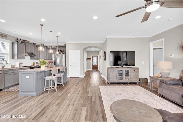 3213 Laughing Gull Ter, Wilmington, NC 28412 - living room with arched walkways, a ceiling fan, light wood finished floors, ornamental molding, and recessed lighting