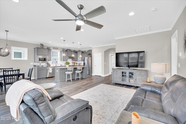 3213 Laughing Gull Ter, Wilmington, NC 28412 - living room featuring a ceiling fan, arched walkways, wood finished floors, baseboards, and ornamental molding