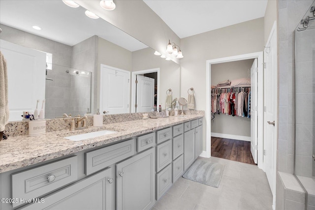 3213 Laughing Gull Ter, Wilmington, NC 28412 - bathroom featuring double vanity, tiled shower, a spacious closet, and tile patterned floors