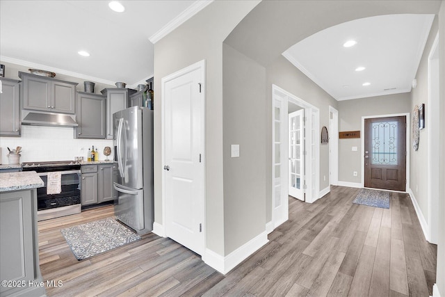 3213 Laughing Gull Ter, Wilmington, NC 28412 - kitchen with appliances with stainless steel finishes, under cabinet range hood, gray cabinetry, arched walkways, and light wood-style floors