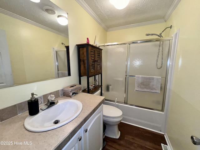 22541 Henry St, Laurel Hill, NC 28351 - full bathroom featuring a textured ceiling, wood finished floors, vanity, shower / bath combination with glass door, and toilet