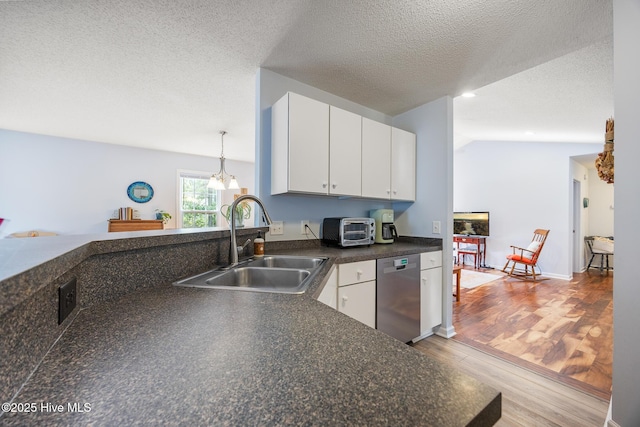 130 Woodgreen Ln, Aberdeen, NC 28315 - kitchen featuring stainless steel dishwasher, a sink, dark countertops, wood finished floors, and a textured ceiling