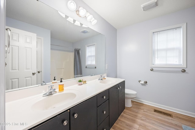 130 Woodgreen Ln, Aberdeen, NC 28315 - bathroom featuring baseboards, toilet, double vanity, wood finished floors, and curtained shower