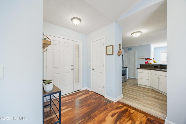 130 Woodgreen Ln, Aberdeen, NC 28315 - foyer featuring light wood-style floors, a textured ceiling, and baseboards