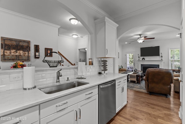 513 Belhaven Dr, Wilmington, NC 28411 - kitchen with stainless steel dishwasher, a sink, arched walkways, a ceiling fan, and light wood-style floors