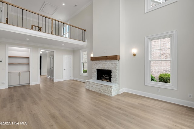 1401 Regatta Dr, Wilmington, NC 28405 - unfurnished living room featuring a high ceiling, crown molding, baseboards, light wood-type flooring, and a fireplace