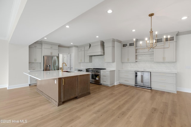 1401 Regatta Dr, Wilmington, NC 28405 - kitchen featuring appliances with stainless steel finishes, premium range hood, a sink, wine cooler, and light countertops