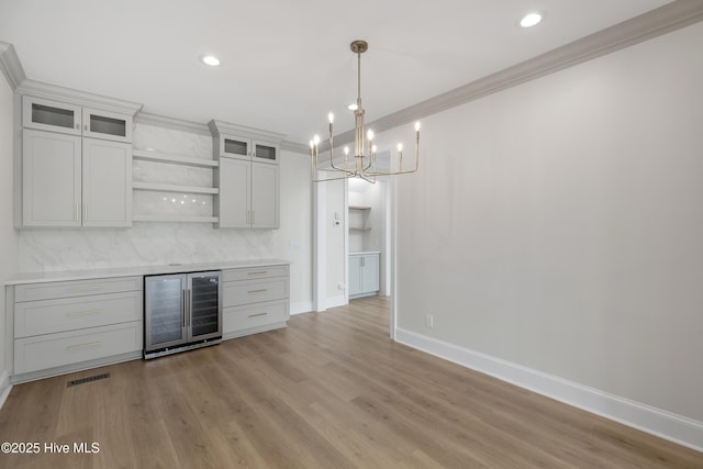 1401 Regatta Dr, Wilmington, NC 28405 - indoor dry bar featuring beverage cooler, baseboards, a chandelier, decorative backsplash, and crown molding