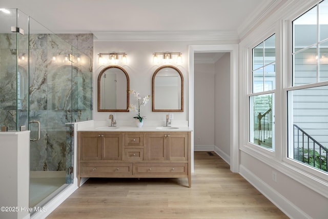 1401 Regatta Dr, Wilmington, NC 28405 - bathroom featuring double vanity, a marble finish shower, ornamental molding, baseboards, and wood finished floors