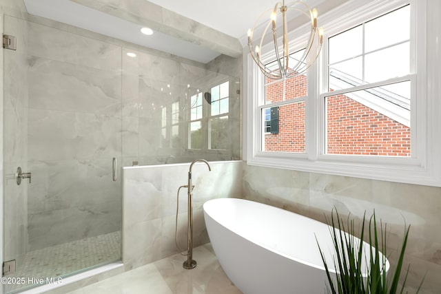 1401 Regatta Dr, Wilmington, NC 28405 - bathroom featuring a freestanding tub, a stall shower, a chandelier, tile walls, and marble finish flooring