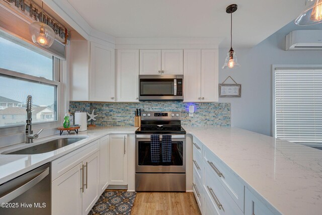 2006 N Shore Dr Unit B, Surf City, NC 28445 - kitchen with stainless steel appliances, a wall mounted air conditioner, a sink, white cabinets, and backsplash