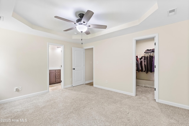 302 Boxwood Ct, Jacksonville, NC 28540 - unfurnished bedroom with a tray ceiling, a walk in closet, light colored carpet, and a closet