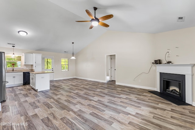 302 Boxwood Ct, Jacksonville, NC 28540 - unfurnished living room featuring light wood finished floors, a ceiling fan, lofted ceiling, baseboards, and a fireplace