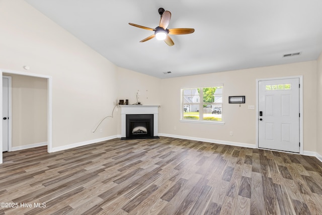 302 Boxwood Ct, Jacksonville, NC 28540 - unfurnished living room with ceiling fan, wood finished floors, baseboards, a fireplace with flush hearth, and lofted ceiling