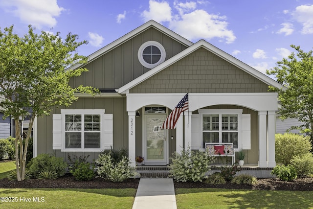 2212 Lakeside Cir, Wilmington, NC 28401 - view of front of house with board and batten siding, a front lawn, and covered porch