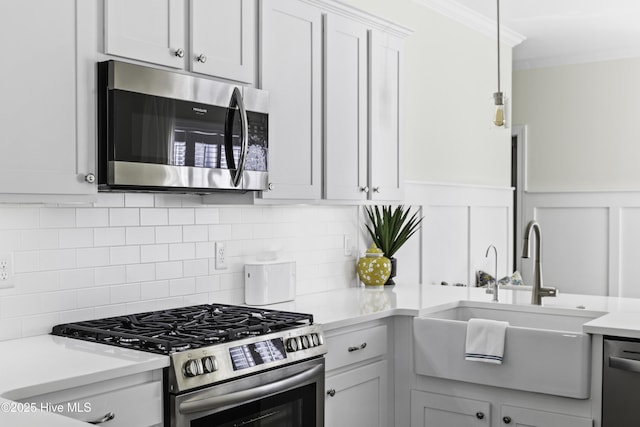 2212 Lakeside Cir, Wilmington, NC 28401 - kitchen with appliances with stainless steel finishes, light countertops, backsplash, white cabinets, and a wainscoted wall