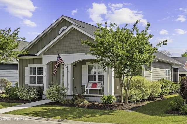 2212 Lakeside Cir, Wilmington, NC 28401 - view of front facade with board and batten siding, a porch, and a front yard