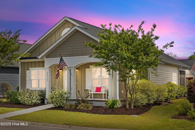 2212 Lakeside Cir, Wilmington, NC 28401 - view of front of property featuring board and batten siding, covered porch, and a lawn