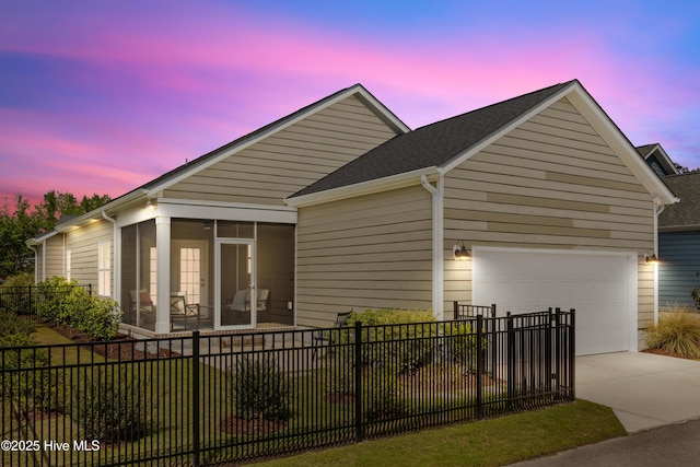 2212 Lakeside Cir, Wilmington, NC 28401 - view of front of house with a sunroom, driveway, an attached garage, and a shingled roof