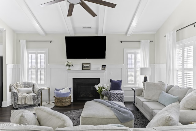 2212 Lakeside Cir, Wilmington, NC 28401 - living room featuring a ceiling fan, wainscoting, dark wood-type flooring, a glass covered fireplace, and plenty of natural light