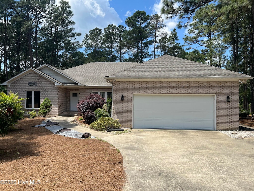 38 Windsong Pl, Whispering Pines, NC 28327 - single story home featuring brick siding, concrete driveway, and a shingled roof