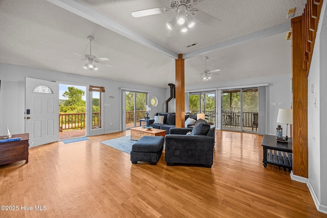 1005 Pirate Cove Cir, Oriental, NC 28571 - living room featuring a ceiling fan, a textured ceiling, light wood finished floors, plenty of natural light, and baseboards