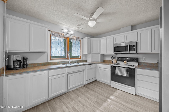 1005 Pirate Cove Cir, Oriental, NC 28571 - kitchen with stainless steel microwave, electric stove, white dishwasher, a sink, and white cabinets