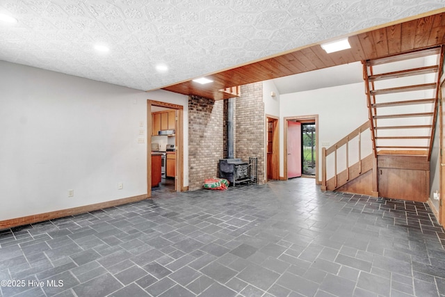 4969 Redman Rd, Rocky Mount, NC 27803 - unfurnished living room with stairway, a wood stove, and baseboards