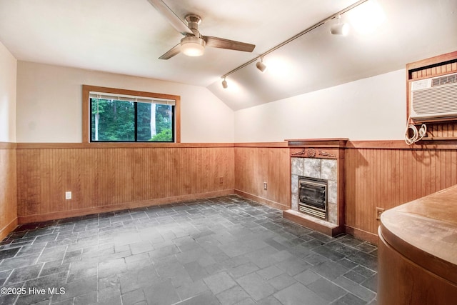 4969 Redman Rd, Rocky Mount, NC 27803 - spare room with a wainscoted wall, wood walls, rail lighting, ceiling fan, and a tiled fireplace