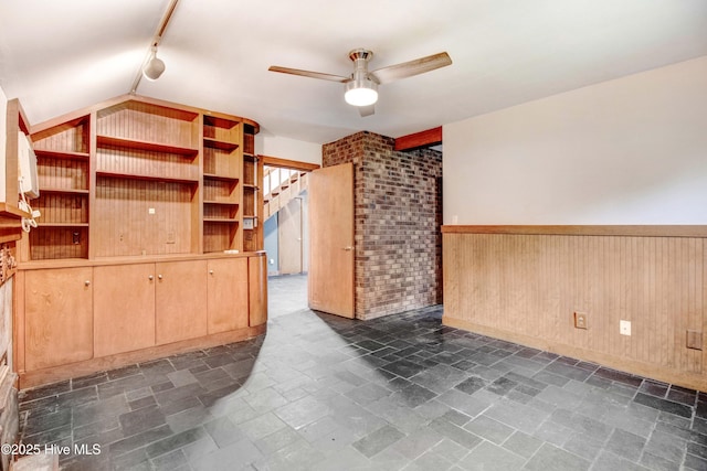 4969 Redman Rd, Rocky Mount, NC 27803 - spare room featuring ceiling fan, track lighting, wainscoting, wood walls, and brick wall