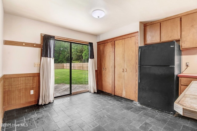 4969 Redman Rd, Rocky Mount, NC 27803 - kitchen with freestanding refrigerator, stone tile floors, and wainscoting