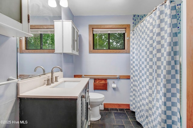 4969 Redman Rd, Rocky Mount, NC 27803 - full bath with stone tile flooring, toilet, vanity, baseboards, and curtained shower