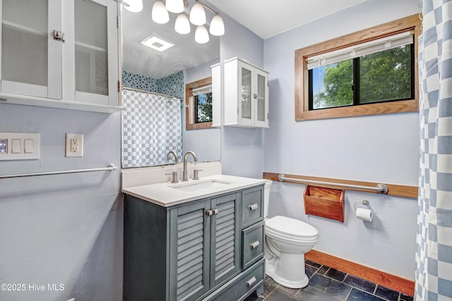 4969 Redman Rd, Rocky Mount, NC 27803 - bathroom featuring plenty of natural light, toilet, vanity, and baseboards