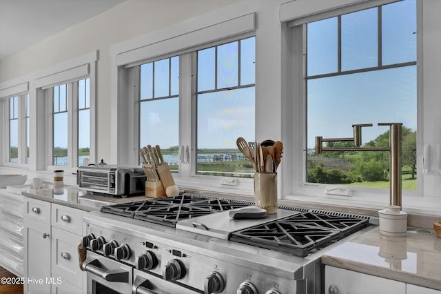 1205 Kings Lndg, Hampstead, NC 28443 - kitchen with high end stove, white cabinets, a water view, and light stone countertops