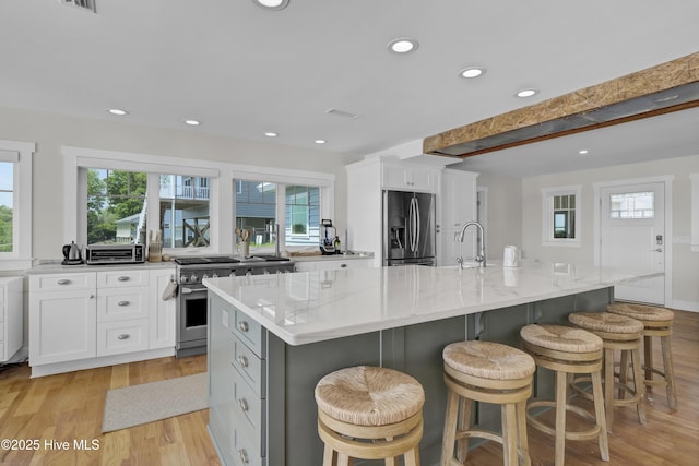 1205 Kings Lndg, Hampstead, NC 28443 - kitchen featuring stainless steel appliances, light wood-type flooring, white cabinetry, recessed lighting, and light stone countertops