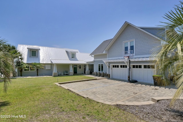 1205 Kings Lndg, Hampstead, NC 28443 - view of front of house featuring an attached garage, a front yard, metal roof, and a standing seam roof